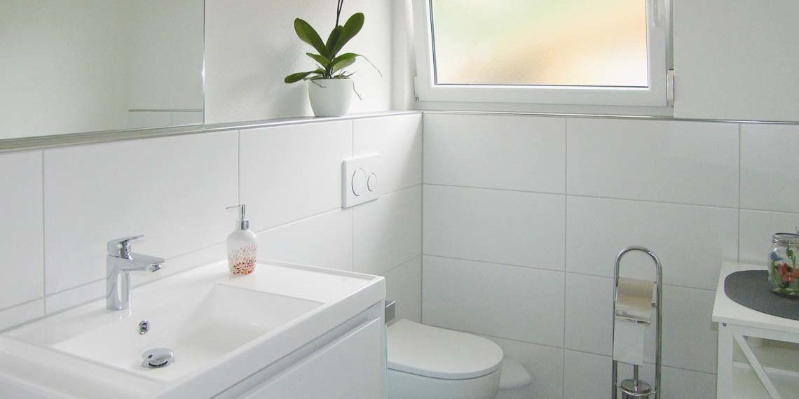 Barrierefreie, begehbare Duschinsel und lichtdurchflutete Gästetoilette
